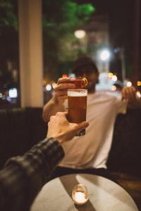 a person holding up a glass of beer at The Society Hotel in Portland