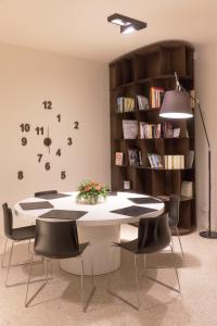 a table and chairs in a room with a book shelf at Boiardo Hotel in Scandiano