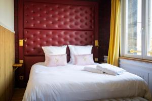 Schlafzimmer mit einem großen Bett mit einem roten Kopfteil in der Unterkunft Les chambres du Waterzooi in Dunkerque