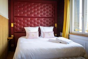 a bedroom with a large bed with a red headboard at Les chambres du Waterzooi in Dunkerque