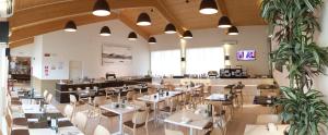 a restaurant with tables and chairs in a room at Boiardo Hotel in Scandiano