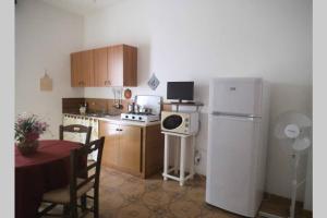 una cucina con tavolo e frigorifero bianco di CASA Spezie 1PD a Castellammare del Golfo
