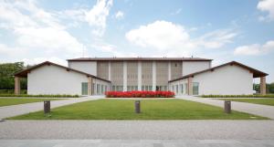 ein großes Gebäude mit roten Blumen davor in der Unterkunft Boiardo Hotel in Scandiano