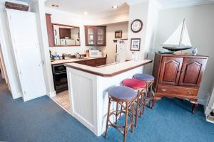 a kitchen with a bar with stools and a sink at 110 Water Street Inn in Boyne City