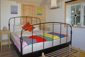 a bedroom with a metal bed with colorful blankets at Haus Fjäril in Laxeby