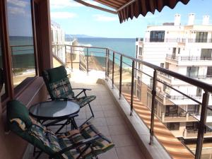 a balcony with two chairs and a table and the ocean at 2-х комнатные апартаменты в г.Поморие Болгария in Pomorie