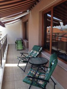 patio z 2 krzesłami i stołem na balkonie w obiekcie 2-х комнатные апартаменты в г.Поморие Болгария w mieście Pomorie