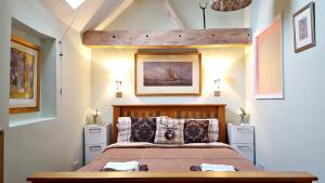 a bedroom with a bed with a wooden headboard at River Nene Cottages in Water Newton