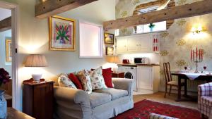 a living room with a couch and a kitchen at River Nene Cottages in Water Newton