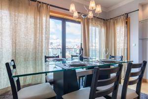 リスボンにあるLovelyStay - Modern apartment in Anjosのダイニングルーム(テーブル、椅子付)、大きな窓が備わります。