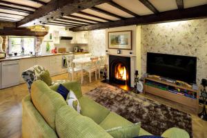 a living room with a couch and a fireplace at River Nene Cottages in Water Newton