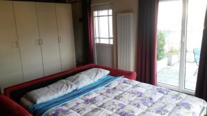 Schlafzimmer mit einem Bett vor einem Fenster in der Unterkunft B&B " Guzzi - Inn " in Mandello del Lario