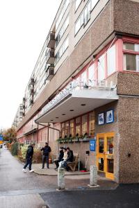 un grupo de personas parados fuera de un edificio en Slottsskogens Hostel, en Gotemburgo