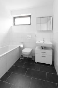 La salle de bains est pourvue d'un lavabo, d'une baignoire et de toilettes. dans l'établissement Quiet Nature Near Cologne 2, à Bergisch Gladbach
