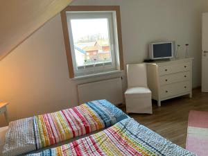 a bedroom with a bed and a tv and a window at Aamon in Zierow