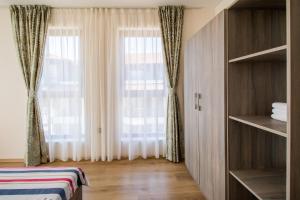 a bedroom with a large window with curtains at Penthouse at White Cliffs in Byala