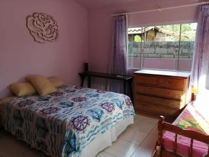 Un dormitorio con una cama y una cómoda y una ventana. en Casa do sossego p/até 9 pessoas, en Garopaba
