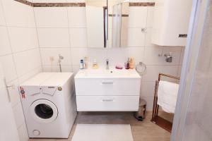 biała łazienka z pralką i umywalką w obiekcie Ferienwohnung Klauber Schöder w mieście Schöder