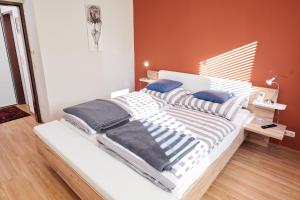 a white bed with blue pillows in a bedroom at Ferienwohnung Klauber Schöder in Schöder