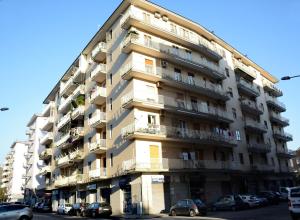 a tall apartment building with cars parked in front of it at Residenza Margherita - Centralissima in Salerno