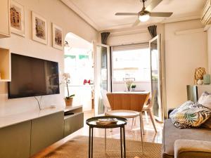 een woonkamer met een bank, een tv en een tafel bij Ático Azalea - Corazón del Carmen, doble balcon, wifi in Murcia