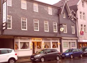 two cars parked in front of a building on a street at Hotel Alt-Lennep in Remscheid