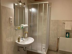 a bathroom with a sink and a shower at Hotel Alt-Lennep in Remscheid