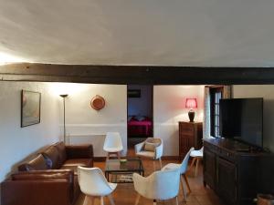sala de estar con sofá y TV en Le Domaine des Tostes, en Bonneville-la-Louvet