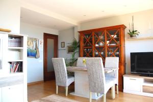 comedor con mesa, sillas y TV en Panier en Osier · Panier en Osier · Charming apartment w/private terrace 2min from sea en Vilassar de Mar