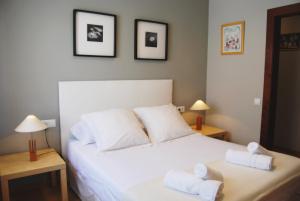 a bedroom with a white bed with two towels on it at Panier en Osier · Panier en Osier · Charming apartment w/private terrace 2min from sea in Vilassar de Mar