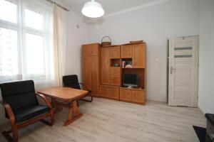 ein Wohnzimmer mit einem Tisch und einem Schrank in der Unterkunft Studio Ali 1 in Sosnowiec