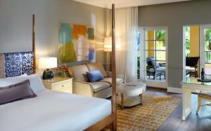 a bedroom with a bed and a living room at La Playa Beach & Golf Resort, a Noble House Resort in Naples