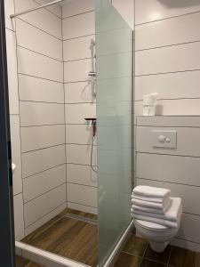 a bathroom with a glass shower stall with a toilet at M70 Apartmanház in Miskolc +36 photos