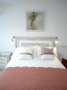 uma cama com um cobertor vermelho e almofadas em CASA KALIMERA em Cuenca