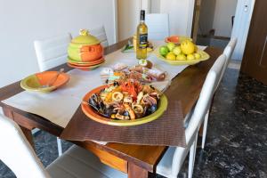a table topped with plates of food on top of a wooden table at Il Mosaico Family Apartments in Mazara del Vallo