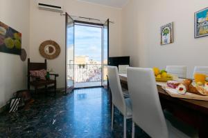 una sala da pranzo con tavolo e sedie e un balcone di Il Mosaico Family Apartments a Mazara del Vallo