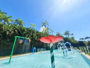 people are playing in a pool with umbrellas at Hotel Portobello Resort & Safari in Mangaratiba