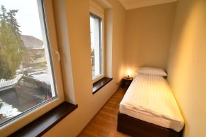 Habitación pequeña con cama y ventana en Tweed house en Budapest