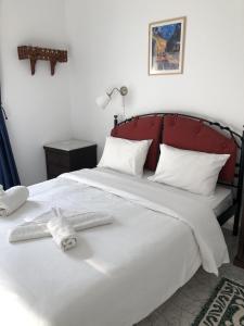 a bedroom with a large white bed with a red headboard at Maistrali in Astypalaia