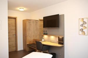 a room with a table and a television on a wall at Gasthof Adler Inneringen in Inneringen-Hettingen