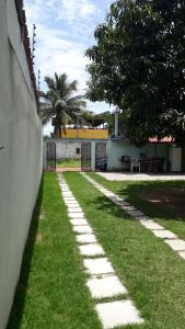 a walkway in the grass next to a wall at Casa de praia P Grande in Fundão