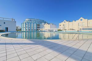 a swimming pool in the middle of a city at Pool & Tennis Beach House in Praia da Barra