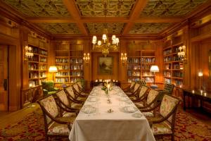 a dining room with a long table in a library at The Cloister in Sea Island