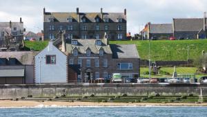 a building on the shore of a body of water at The Home Arms Guesthouse in Eyemouth