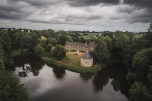 an aerial view of a house on an island in a river at Manoir du Plessix Méen in Pluduno