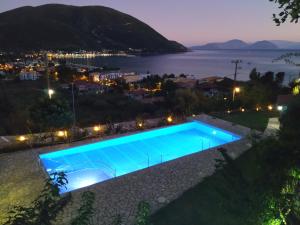 a swimming pool at night with a view of the water at Katerina Lefkada in Vasiliki