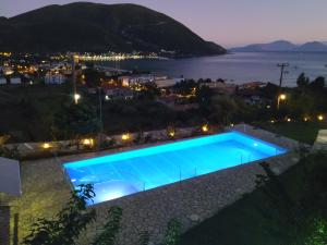 a swimming pool at night with a view of a city at Katerina Lefkada in Vasiliki