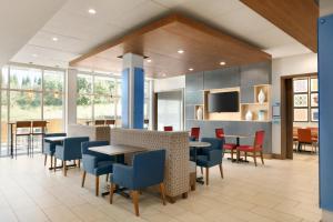 Un comedor con mesas y sillas y ventanas. en Holiday Inn Express & Suites Salisbury by IHG, en Salisbury