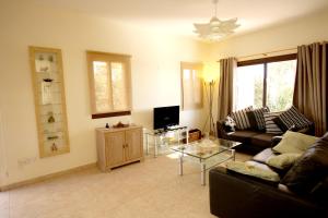 a living room with a couch and a table at Amathousia Villa with private pool and sea view in Pissouri