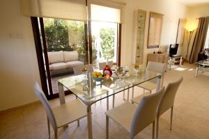 a dining room with a glass table and chairs at Amathousia Villa with private pool and sea view in Pissouri